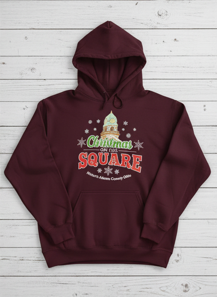 Maroon hoodie with 'Christmas on the Square' design on a light wooden background